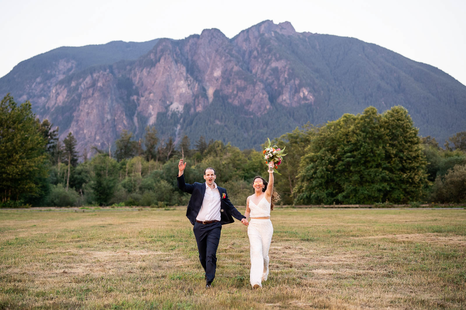 couple runs toward washington wedding photographer in north bend WA