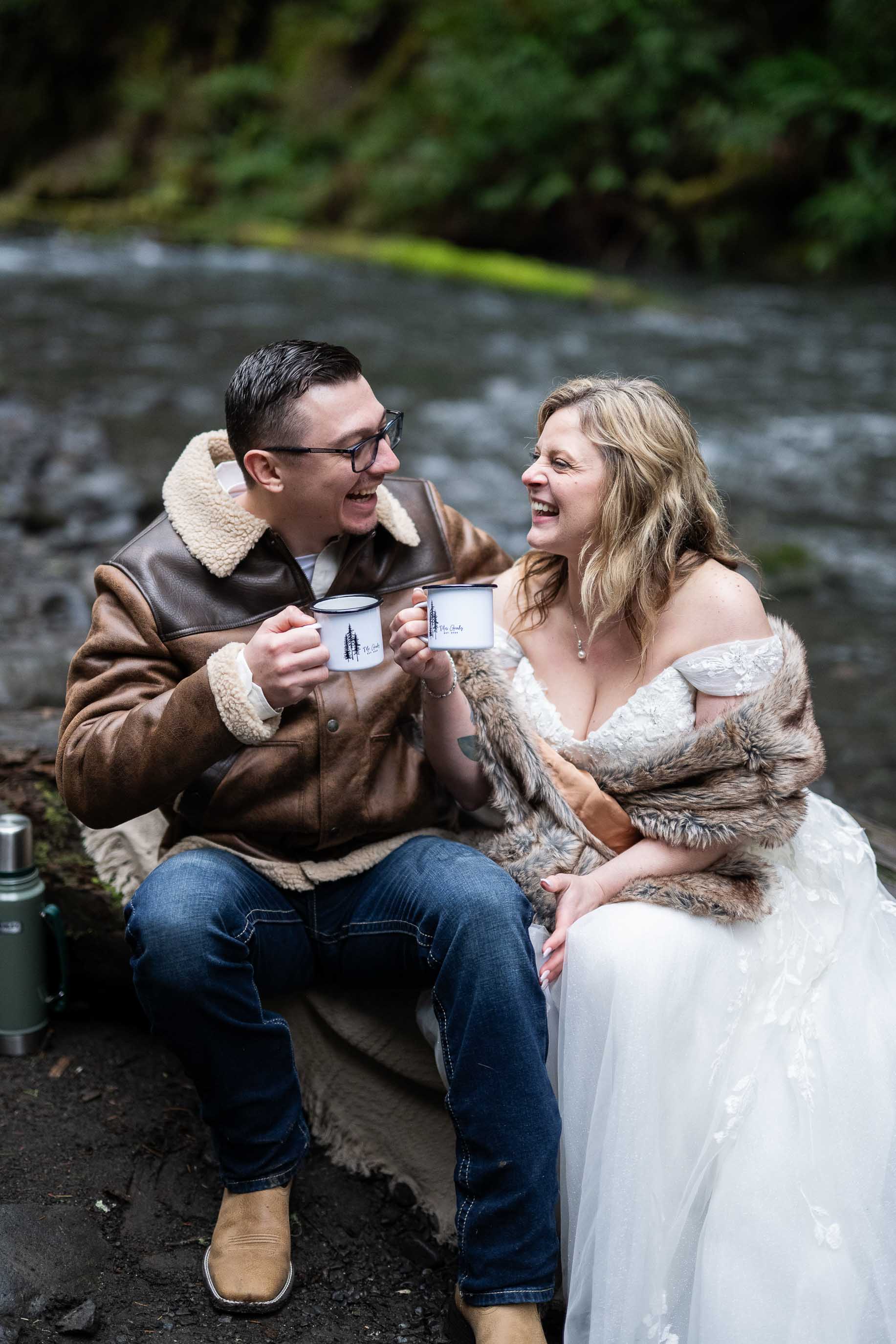 couple sits by river in olympic national park on wedding day