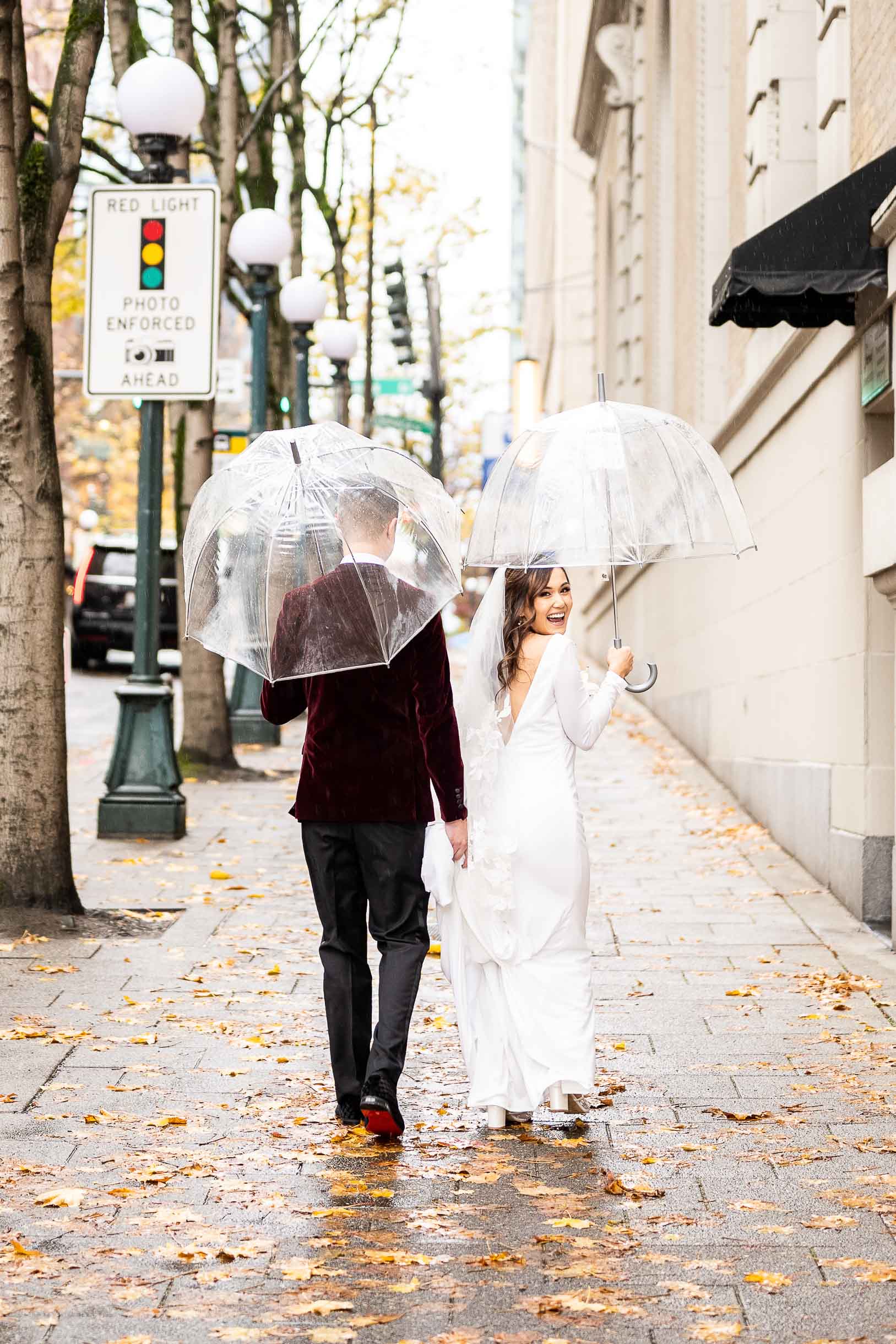 couple poses for seattle wedding photographer while it rains