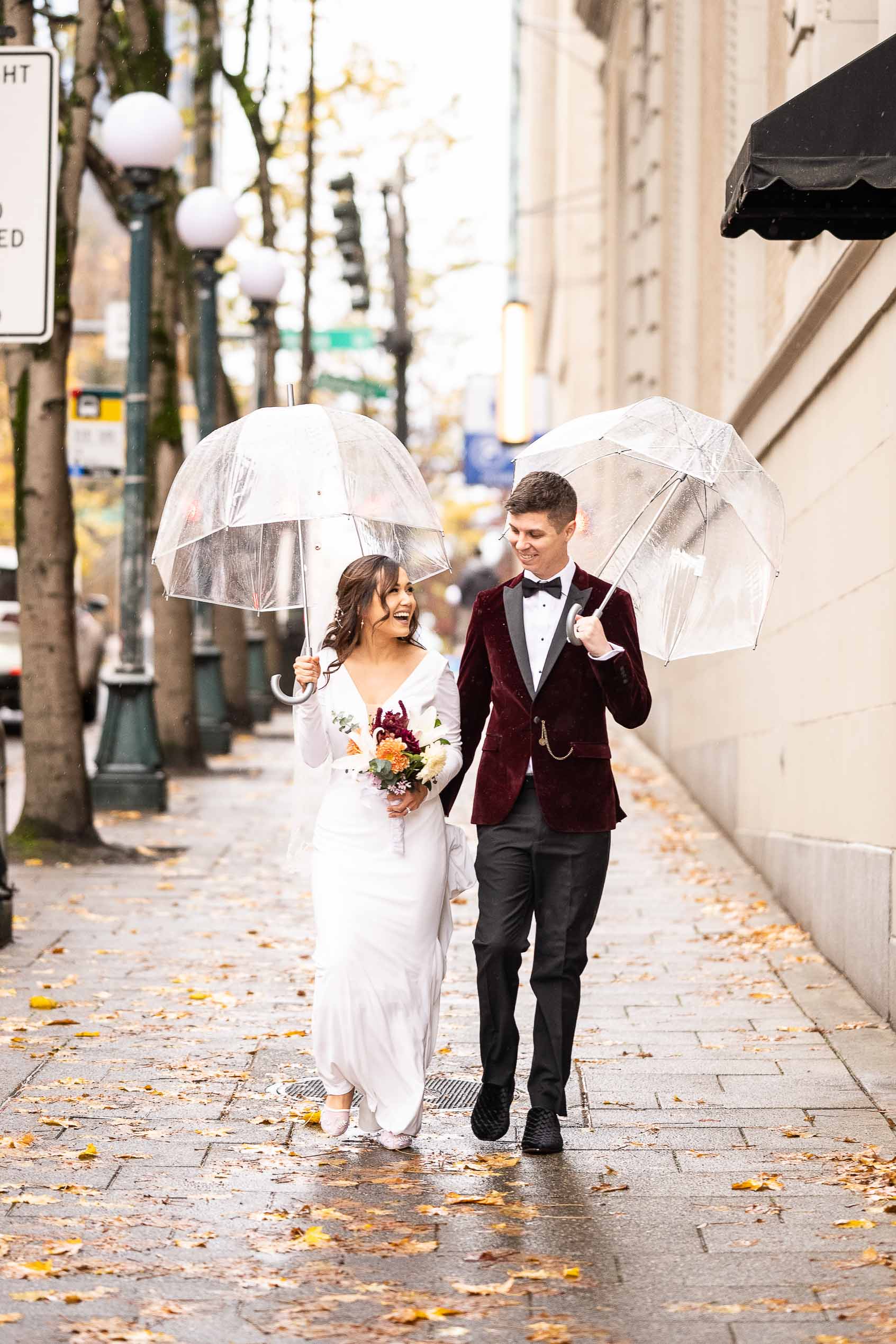 couple uses umbrellas with seattle wedding photographer
